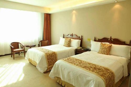 a hotel room with two beds and a window at Yanji Yanbian International Hotel in Yanji