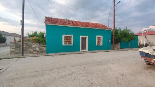 a blue building on the side of a street at Stone Yard in Néa Karváli