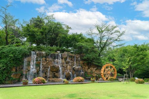a waterfall and a water wheel in a park at Okayama International Hotel in Okayama