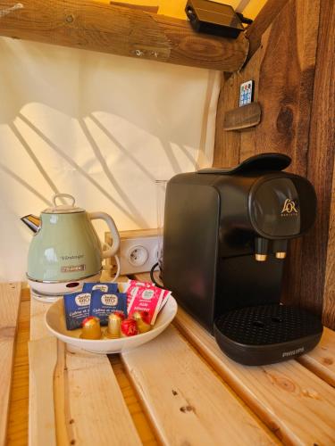 a coffee maker and a plate of food next to a microwave at Quiétude & Nature in Le Boupère