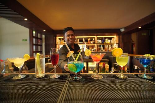 a man behind a bar with a bunch of drinks at Sea Shell Resort & Spa, Havelock in Havelock Island