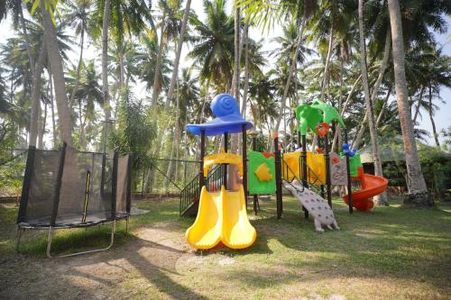 a group of playground equipment in a park with palm trees at Sea Shell Resort & Spa, Havelock in Havelock Island