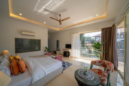a bedroom with a bed and a large window at Koko Maya by Perfectstayz near Morjim Beach in Morjim