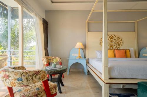 a bedroom with a bed and a chair and a table at Koko Maya by Perfectstayz near Morjim Beach in Morjim