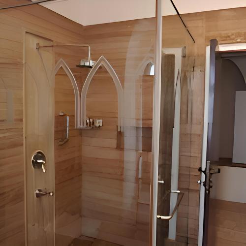 a shower with a glass door in a bathroom at The Postcard Cuelim, Goa in Cansaulim