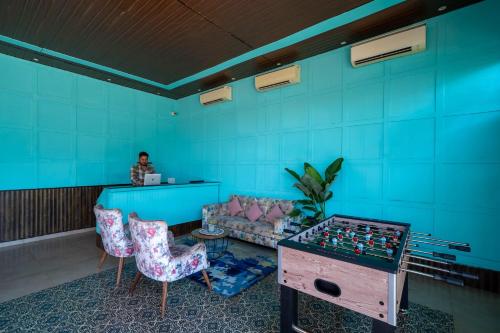 a room with blue walls and a table with chess at Koko Maya by Perfectstayz near Morjim Beach in Morjim