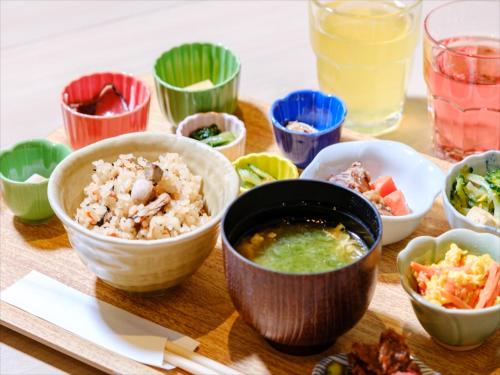 a wooden tray with bowls of food on a table at Hotel Risingsun Miyakojima in Miyako Island
