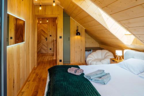 a bedroom with a bed in a room with an attic at Domki Na Wspólnej in Wisła