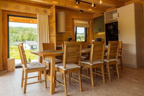 a kitchen with a wooden dining room table and chairs at Domki Na Wspólnej in Wisła
