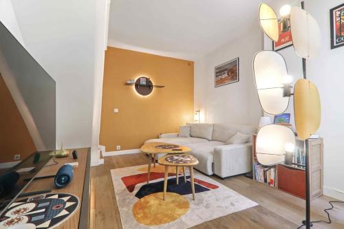 un salon avec un canapé et une table dans l'établissement Le Malicieux, à Paris