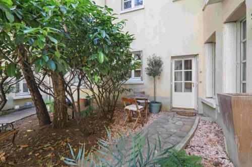 - un jardin avec une table et des chaises en face d'une maison dans l'établissement Le Malicieux, à Paris