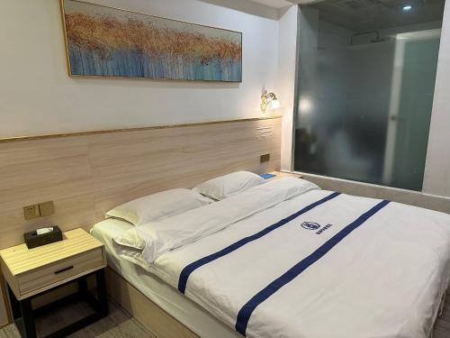 a bedroom with a bed and a table and a picture at Stone Haven in Guilin