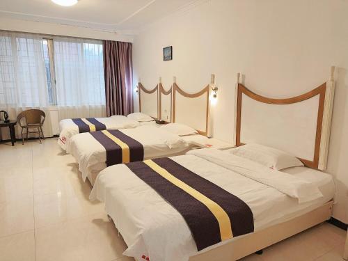 a hotel room with three beds in a room at Stone Haven in Guilin