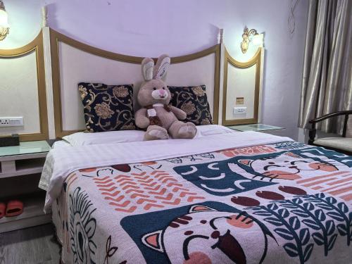 a teddy bear sitting on top of a bed at Stone Haven in Guilin