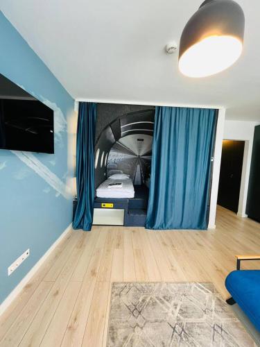 a bedroom with a bed in a room with blue walls at Airliner Apartment in Cluj-Napoca