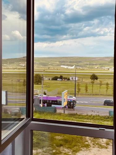 a window with a view of a bus on the road at Airliner Apartment in Cluj-Napoca