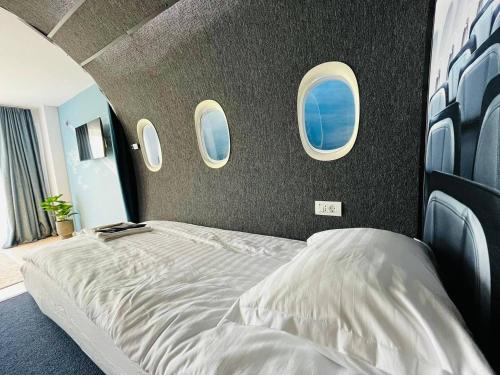 a large bed in a room with three windows at Airliner Apartment in Cluj-Napoca
