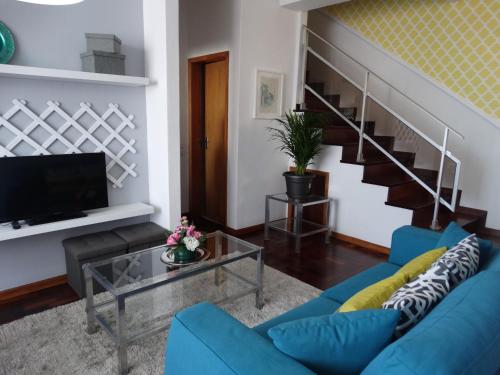 a living room with a blue couch and a staircase at Barreirinha Funcho House in Funchal