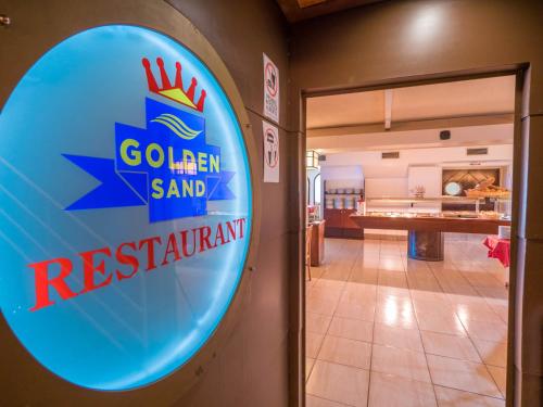 een uithangbord van een restaurant met gouden zandstrand aan de muur bij Hotel Golden Sand in Lloret de Mar