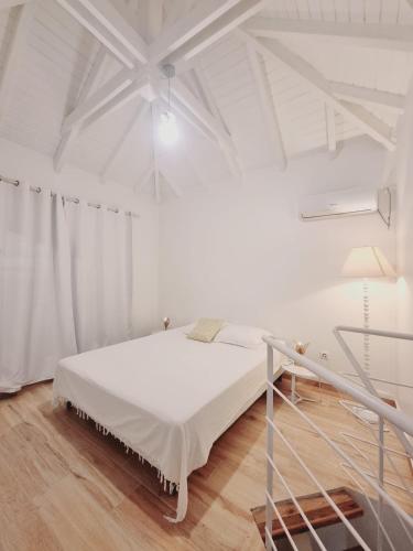 a white bedroom with a bed and a white ceiling at Sandy Bay Villa Opale in Le Moule