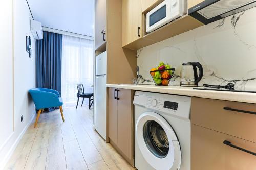 a kitchen with a washing machine in a kitchen at 1 room apartment CITY PLUS 1 in Almaty