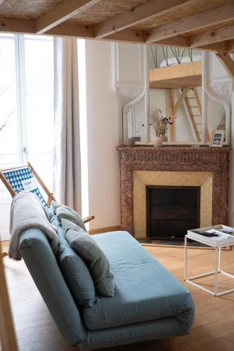 un salon avec un canapé et une cheminée dans l'établissement Studio Vichy patrimoine mondial Villa Marie Celine, à Vichy