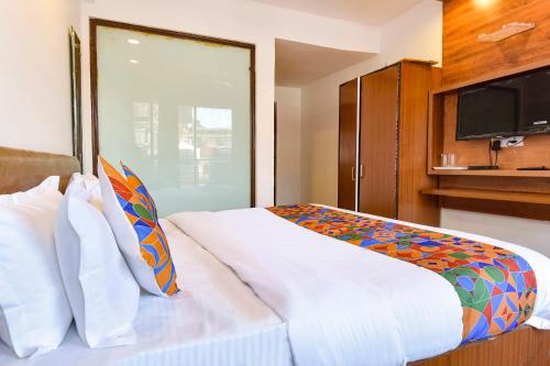 a bedroom with a large white bed with a tv at FabHotel Sikka Royal Classic - Mall road in Mussoorie