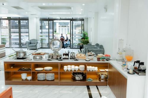 a kitchen with a counter with dishes on it at TQ Helios Hotel & Apartment in An Khê