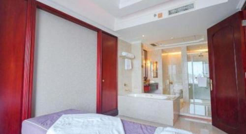 a bathroom with a bed and a tub and a sink at King Century Hotel in Zhongshan