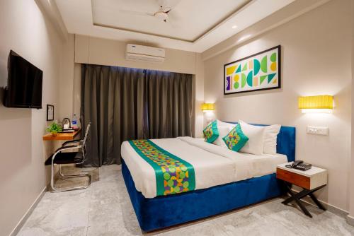 a hotel room with a bed and a television at Treebo Riwaayat Regency in Pune