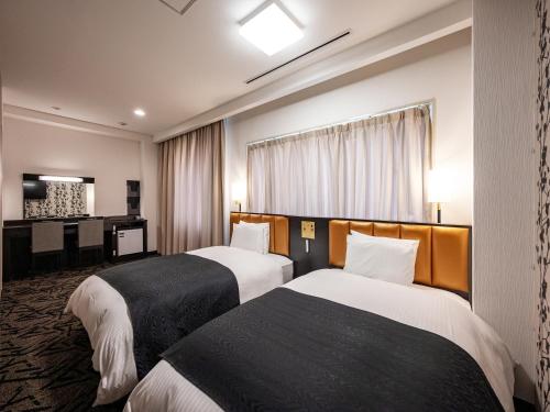 a hotel room with two beds and a television at APA Hotel Shonan Tsujido Ekimae in Fujisawa