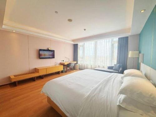 a large bedroom with a large bed and a desk at Lavande Hotel·Dongxing Port in Fangcheng
