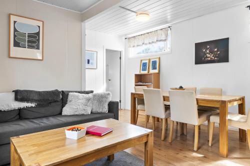 a living room with a couch and a table at Cozy house by the river Ytri Rangá in Hella