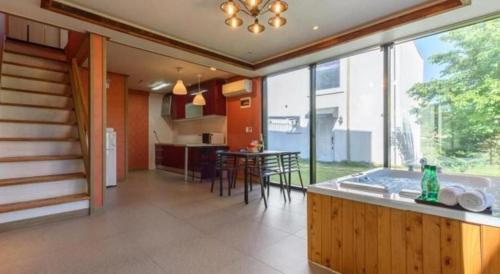 a kitchen and dining room with a large window at All That Water Pension in Gapyeong