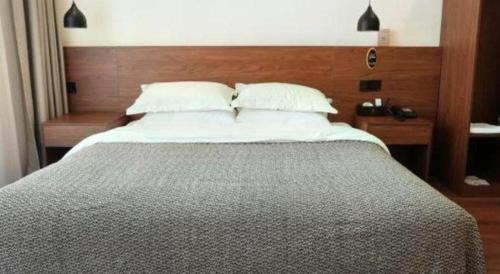a bedroom with a large bed with a wooden headboard at Lijiang Liwang Hotel in Lijiang