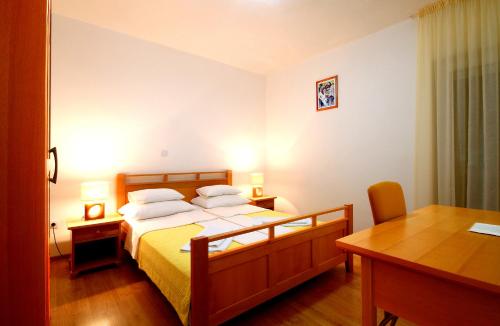 a bedroom with a bed and a desk and a table at Apartments Đurašević in Sveti Stefan