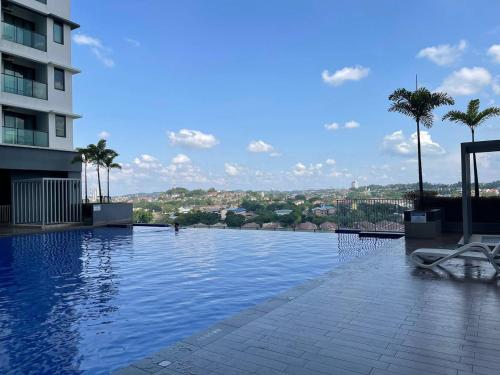 a swimming pool with palm trees and a building at Le Cozy Home UKM BANGI KAJANG BACC GMI UIS in Bangi