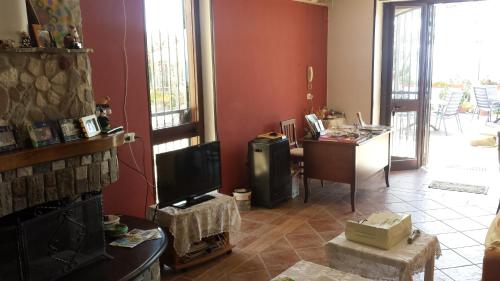 a living room with a tv and a desk in a room at Villa Malandrino Guest House in Agropoli