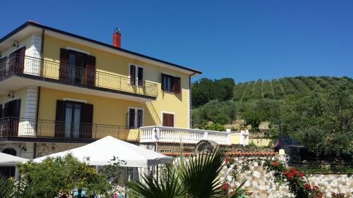 a large yellow building with a hill in the background at Villa Malandrino Guest House in Agropoli