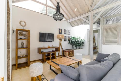 a living room with a couch and a table at Villa Cemacase - Stylish 2BR Villa with Spacious Private Pool & Pool Table in Seseh in Cemagi