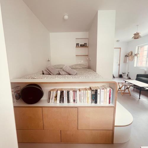 - une chambre avec un lit et une étagère avec des livres dans l'établissement Studio Dizy, à Villers-sur-Mer