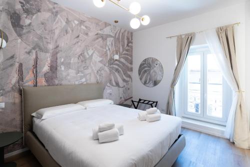 a bedroom with a bed with two white towels on it at Maison Rasella Palace Suites in Rome