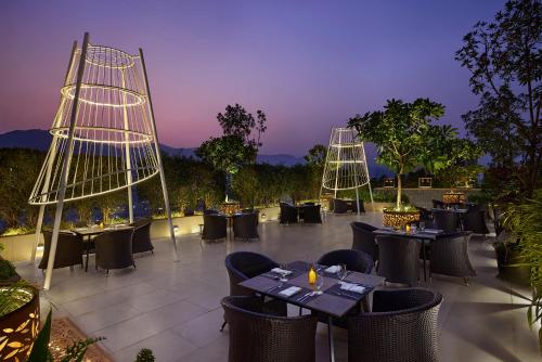a restaurant with tables and chairs at night at Marriott Executive Apartments Navi Mumbai in Navi Mumbai