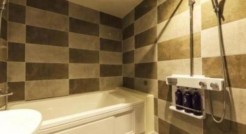 a bathroom with a shower with a tub and a sink at H Hotel in Ulsan