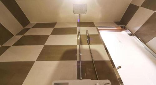 a bathroom with a toilet on a checkered floor at H Hotel in Ulsan
