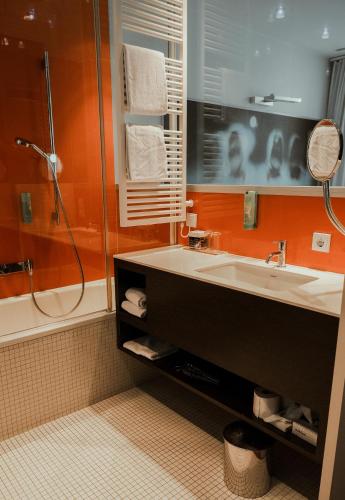 a bathroom with a sink and a shower at arte Hotel Linz in Linz