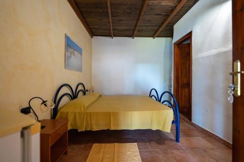 a room with a table with a yellow blanket on it at Agriturismo Piperedda in Irgoli