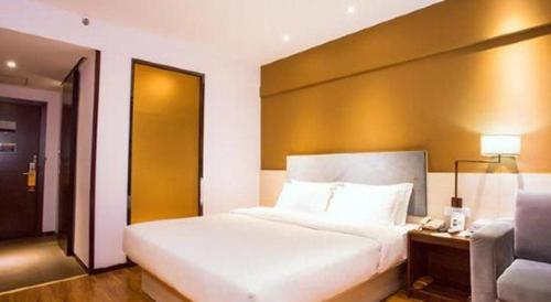 a bedroom with a large white bed and a couch at JTOUR Inn Guilin Two Rivers and Four Lakes Walmart in Guilin