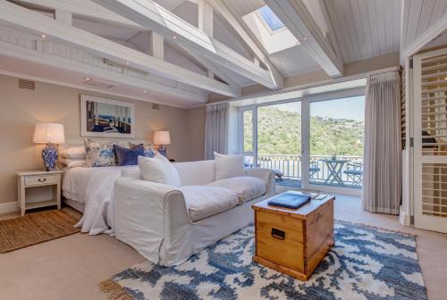 a living room with a white couch and a large window at Amanzi Island Boutique Hotel in Knysna