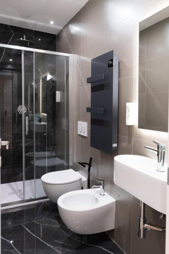 a bathroom with two sinks and a shower and a toilet at Maison Rasella Palace Suites in Rome
